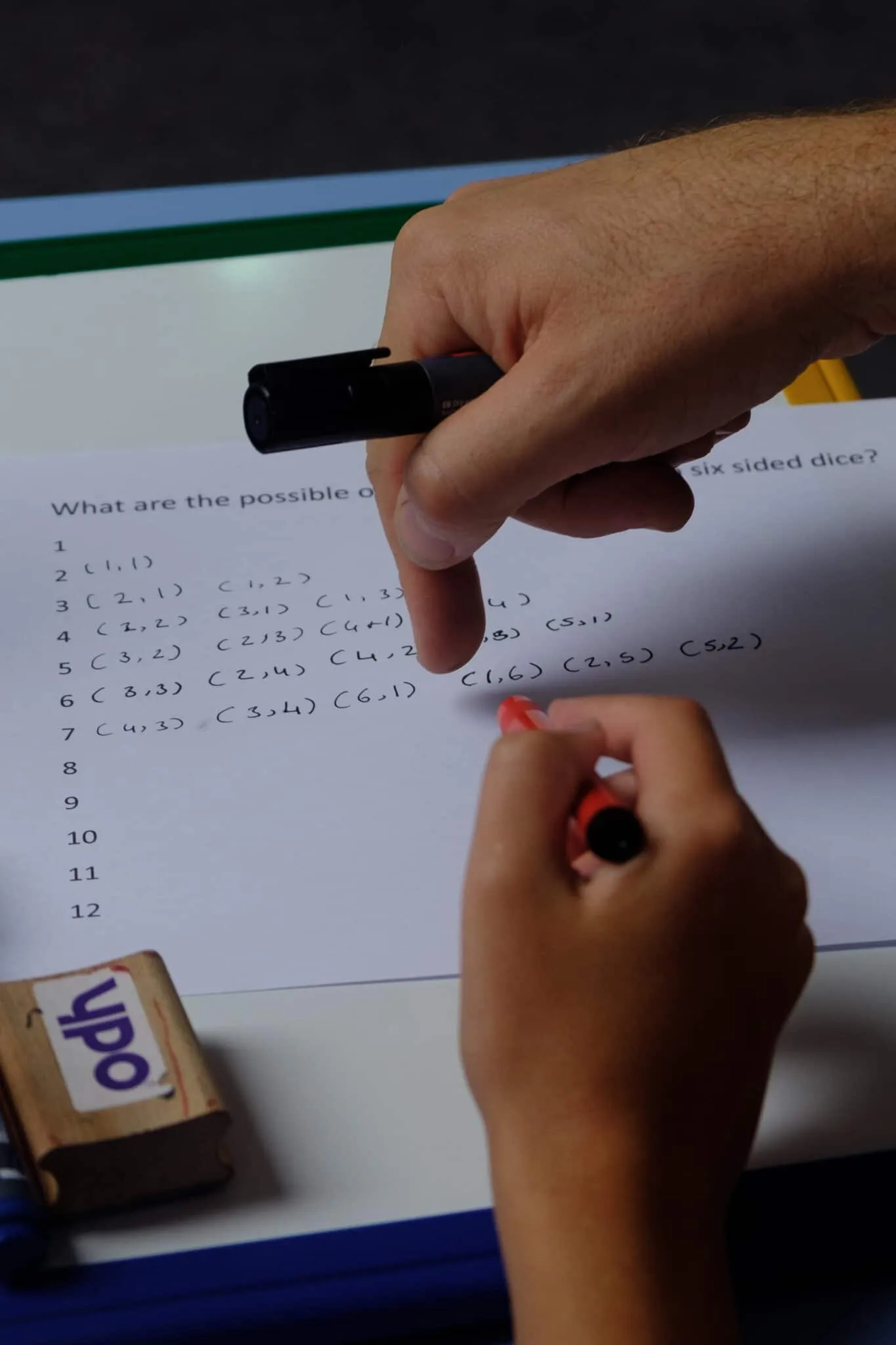 A pupil working on a probability question with a mini whiteboard and pen