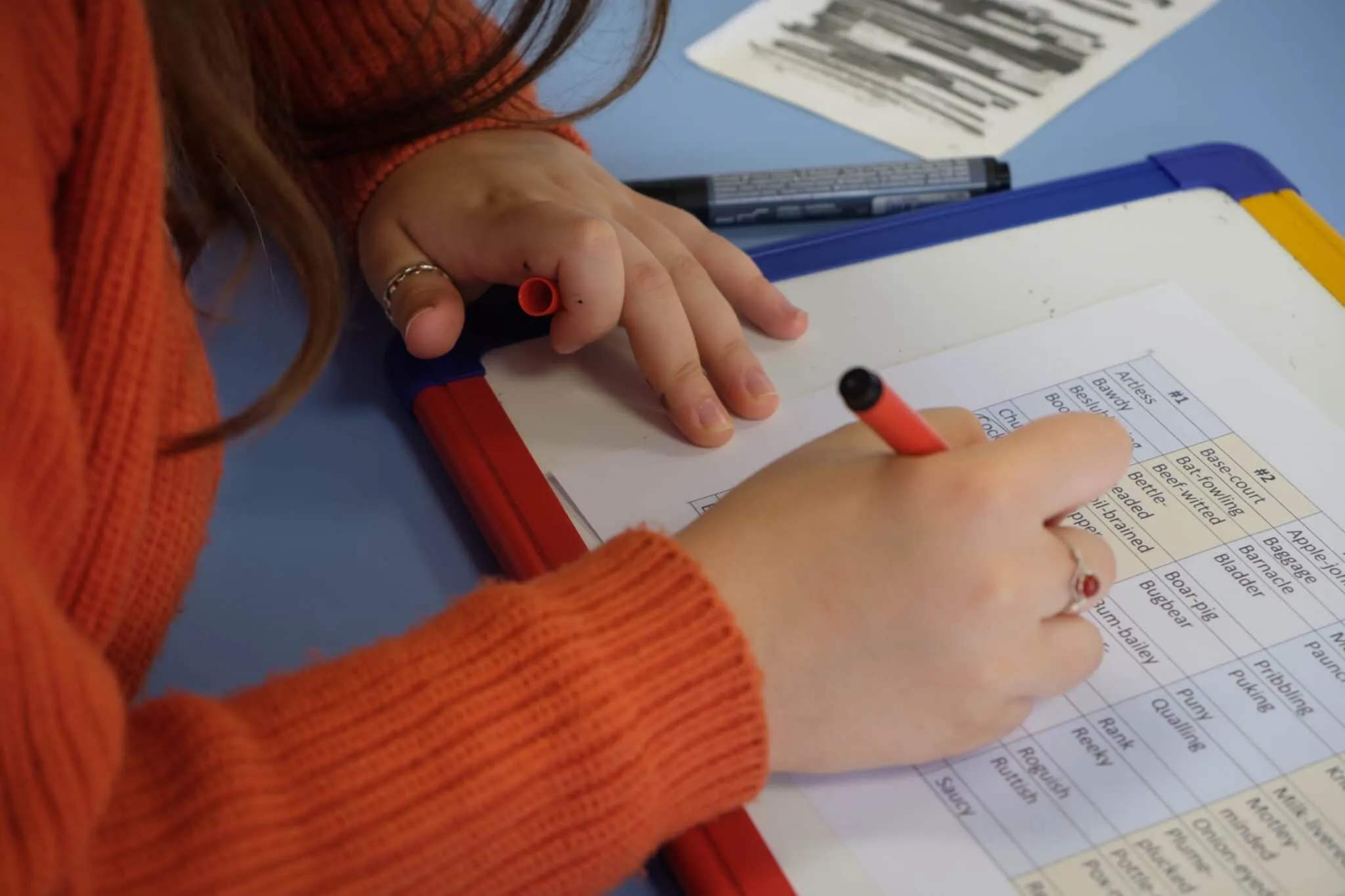 A student writing on a mini whiteboard at the centre